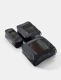 Set of black travel packing cubes on a light gray background