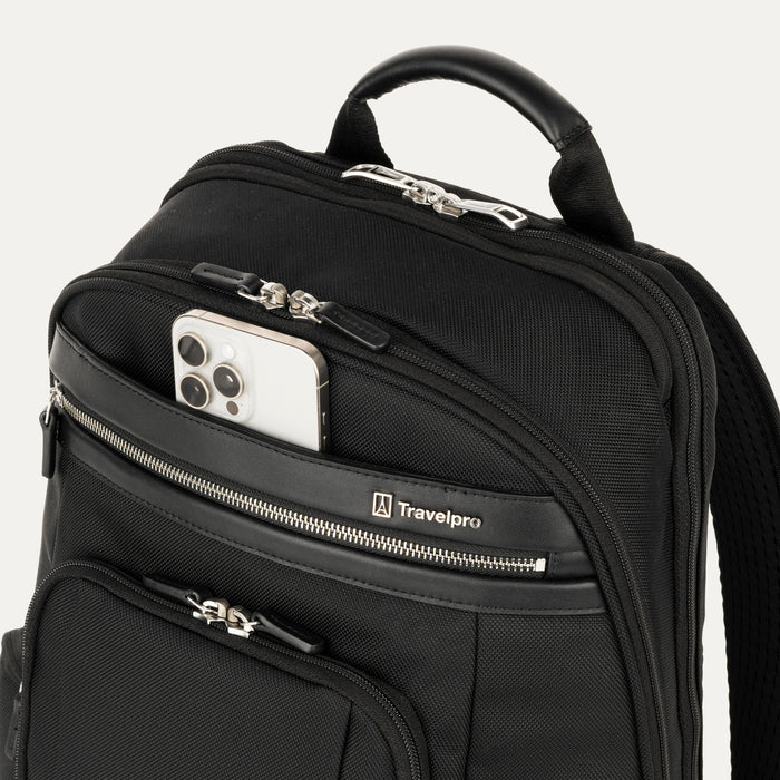 close-up view of the black travelpro platinum elite business laptop backpack 27l, showing a white smartphone being placed into the quickslip front pocket with magnetic closure for easy access.