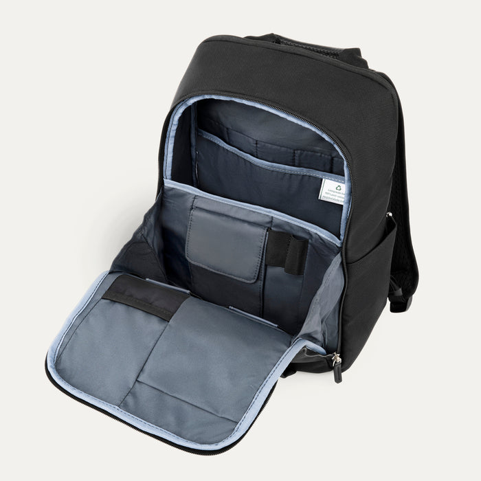 interior view of the front organizational compartment of the shadow black travelpro platinum® elite slim laptop backpack 16l, showing dedicated pockets for pens, small electronics, and a zippered mesh security pocket against a light grey lining.