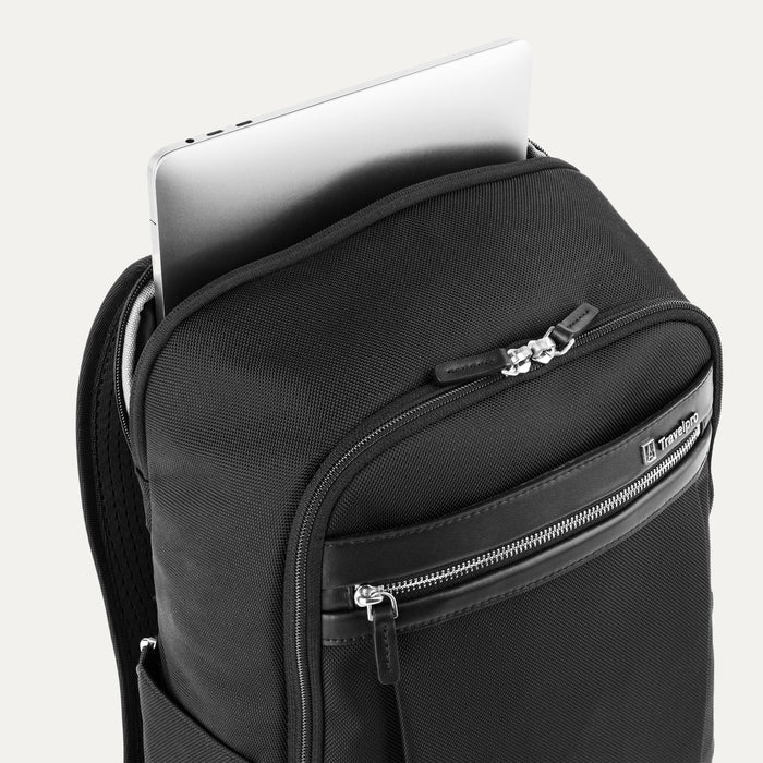 close-up view of the shadow black travelpro platinum® elite slim laptop backpack 16l, showing a silver laptop being inserted into the dedicated padded rear compartment.