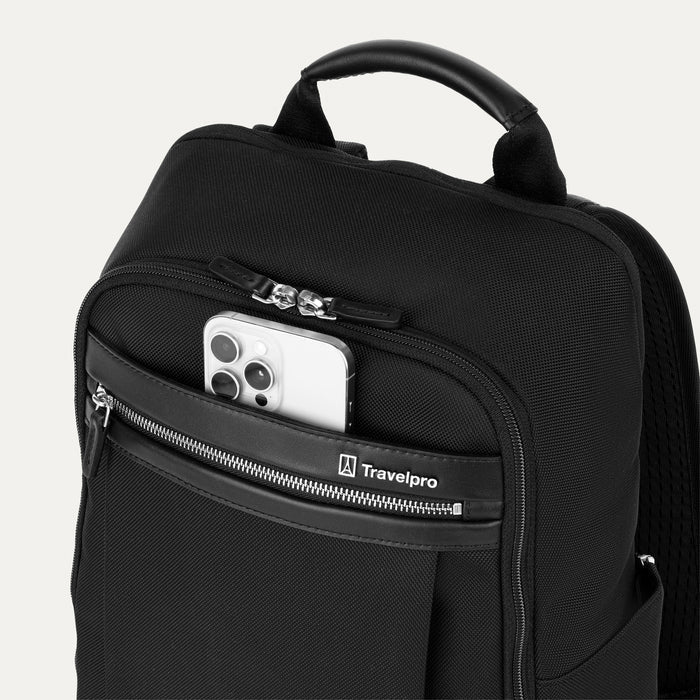 close-up view of the shadow black travelpro platinum® elite slim laptop backpack 16l, showing a white smartphone being placed into the quickslip front pocket with magnetic closure and premium leather trim.