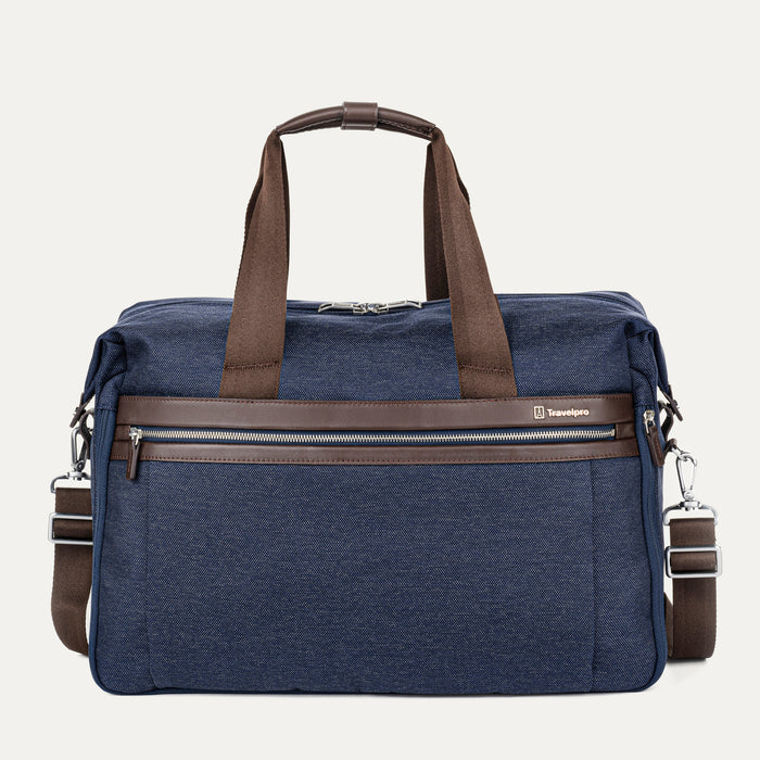 Front view of the Travelpro Platinum Elite Soft Duffel in True Navy, showing brown leather trim, dual top handles, front zippered pocket, and detachable shoulder strap against a white background.