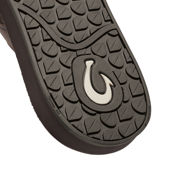 Dark gray shoe sole with geometric tread pattern and cream-colored horseshoe logo.