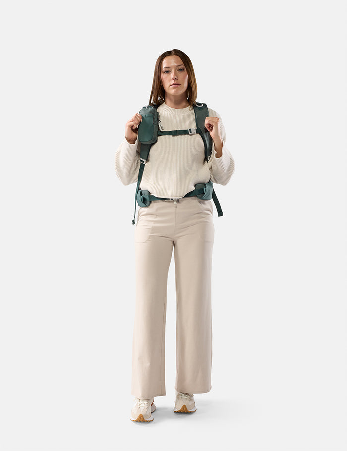 Woman wearing a green backpack on a white background