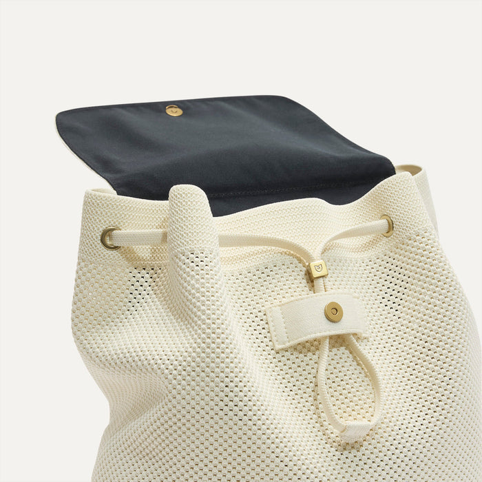 A close up of The Cinch Backpack in Coconut Crochet showing the drawstring closure.