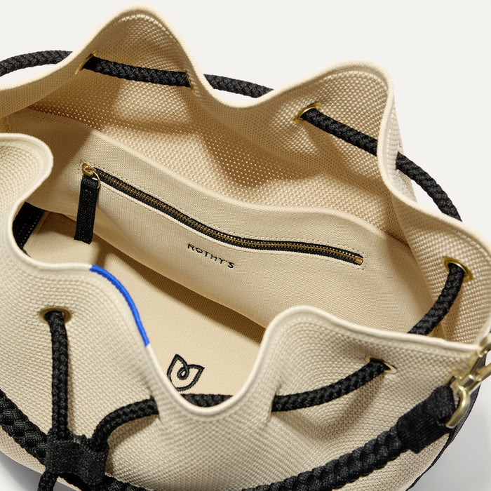 A close up of The Cinch Bucket Bag in Black and White Raffia-Knit showing the interior pockets.