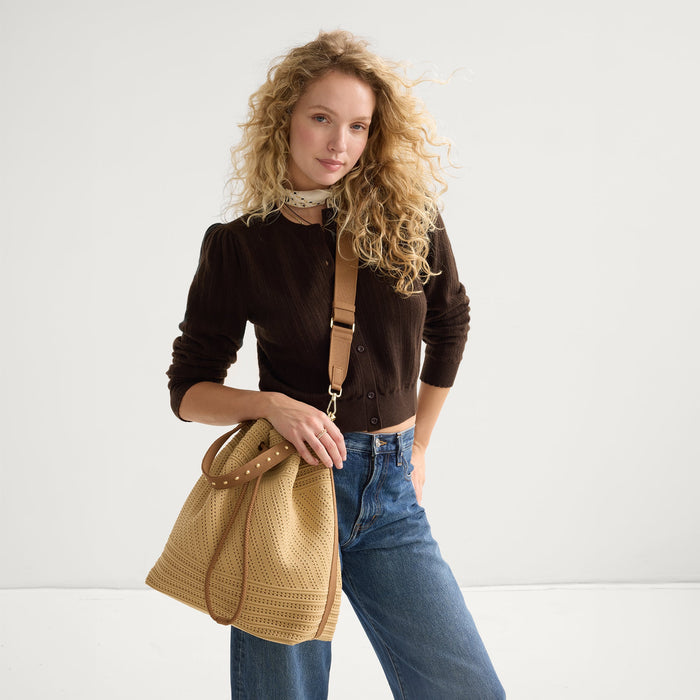 hover | Model wearing The Cinch Bucket Bag in Brown Butter Crochet shown from the front.