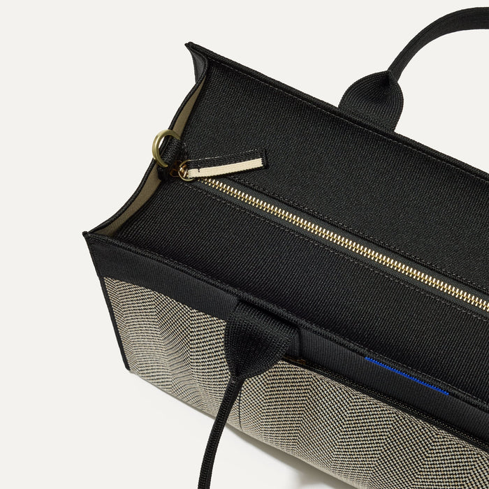 The Classic Tote in Black Herringbone, shown from above, with the top zipper closed.