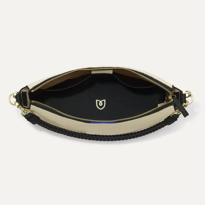 The Daily Crossbody in Black and White Raffia-Knit,  shown from the top down, with zipper open and interior exposed.