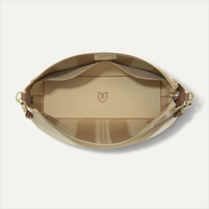 The Daily Crossbody in Oat Latte,  shown from the top down, with zipper open and interior exposed.