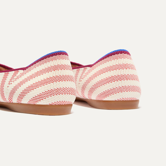 Close up of the heel of The Daily Flat in Coral Cabana Stripe, with Rothy's signature blue halo.