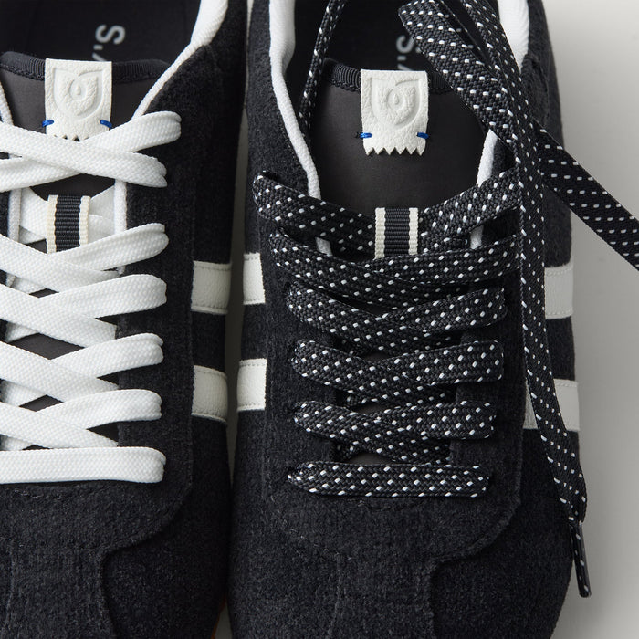 Overlay:: Extra pair of laces included—swap for a new look anytime. | Alt:: Close up of the top of The Ivy Sneaker in ReVelvet Black, showing different lace choices.