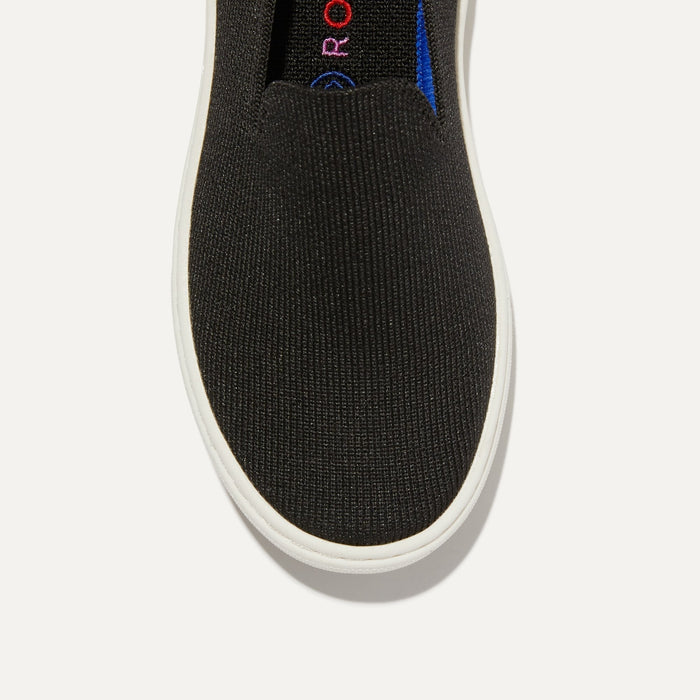 The Kids slip-on Sneaker in Black shown from the top view with detailing of the front of the shoe.