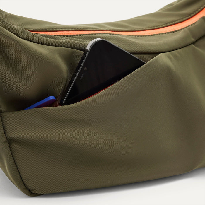 The Travel Sling in Forest  shown closed from the top showcasing the side pocket.