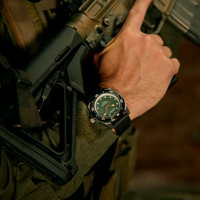 Closeup Shot of Kore Essentials Timberland Watch on Mans Wrist as He Tilts Rifle