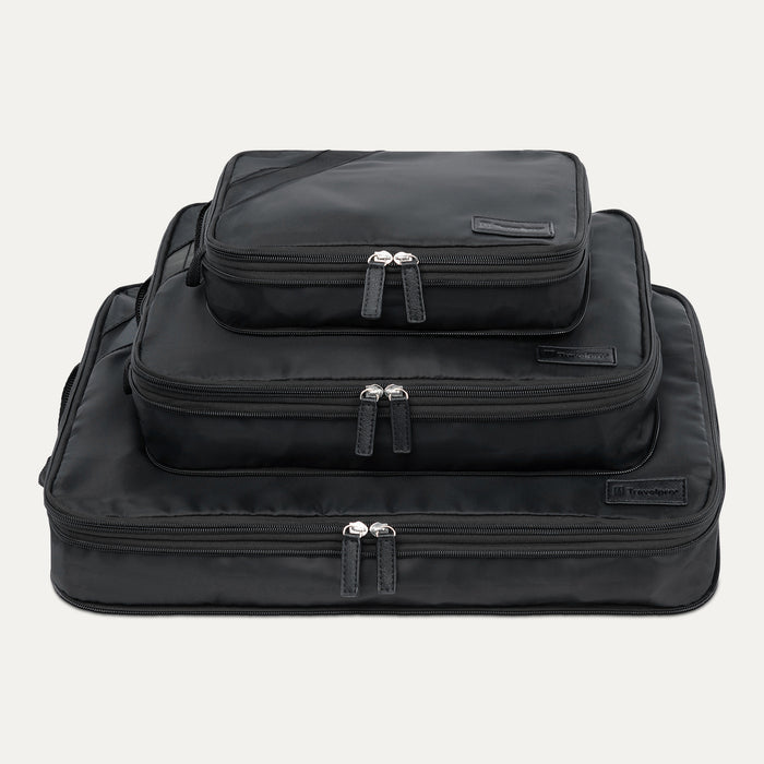 A set of three black Travelpro packing cubes in sizes XL, L, and M, stacked inside each other with zipper closures visible.