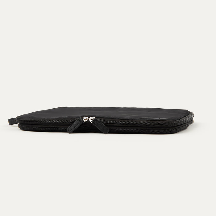 Large Travelpro packing cube in black with a side handle and dual zipper closure, shown compressed.