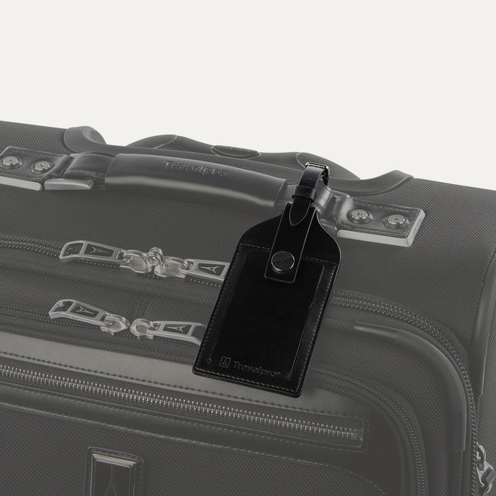 Travelpro Essentials Leather Luggage Tag in Black, attached to suitcase handle with secure buckle strap.