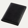A black leather passport cover with the Travelpro brand logo visible on the lower side.