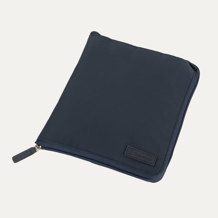 Close-up view of the Travelpro Essentials SparePack Foldable Duffel 2.0 in Navy, showing the bag fully packed and zipped into its compact, flat storage pouch, highlighting the embossed Travelpro branding on the front.