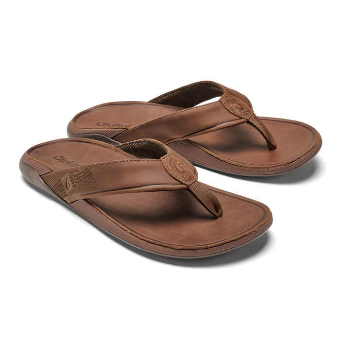 Pair of tan leather thong sandals with textured straps and rounded toe posts.