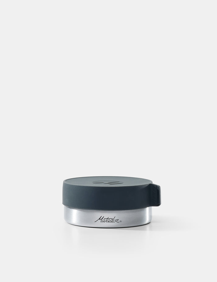 Silver container with a black lid on a white background