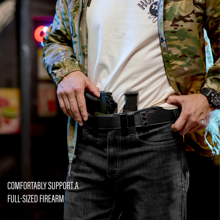 Man wearing a black Kore Essentials black tactical nylon gun belt with an X12 buckle. There is text that reads "comfortable support a full-sized firearm."